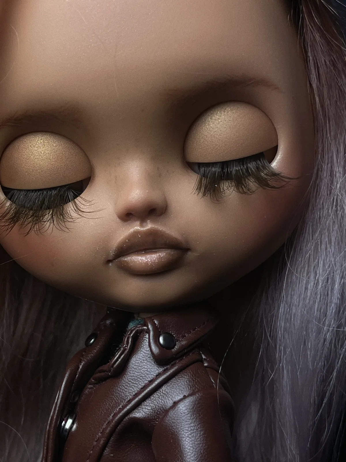 Detalle del maquillaje de ojos cerrados y el rostro de Ama