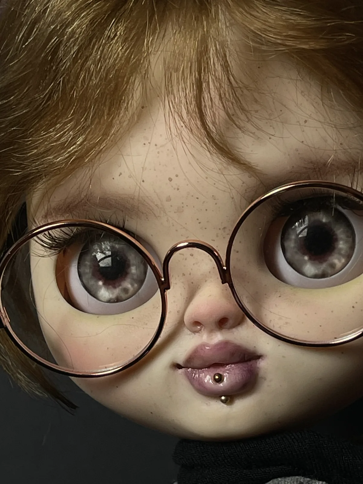 Retrato de Lia con gafas redondas y maquillaje de pecas