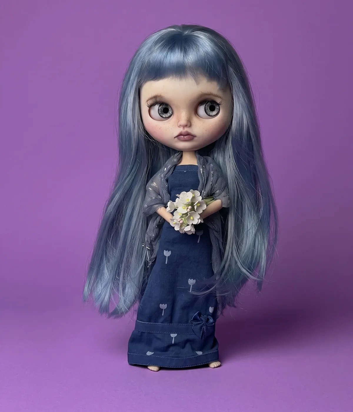Tina, muñeca de autor de cabello azul con vestido azul y flores blancas
