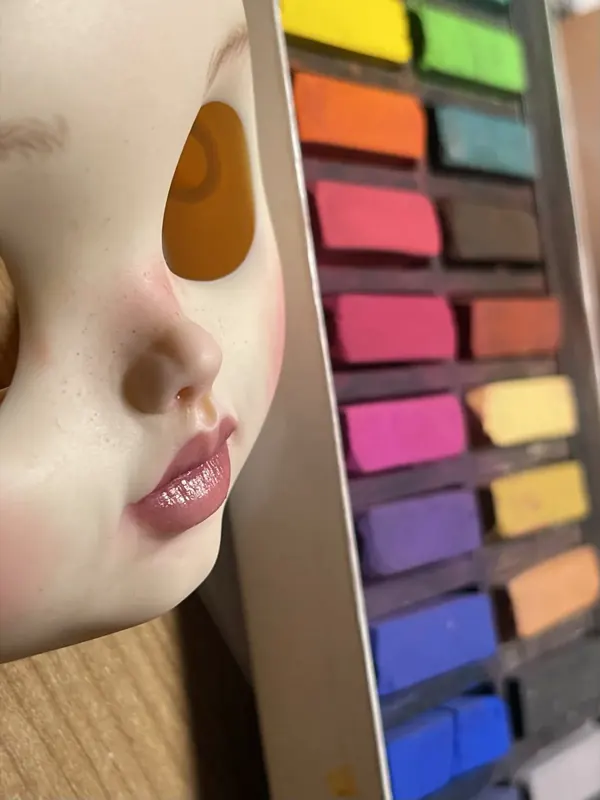 Rostro junto a una caja de pasteles de colores