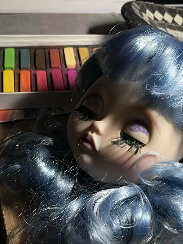 Rostro con peluca azul sobre la mesa de trabajo
