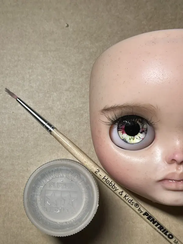 Rostro terminado junto a un pincel fino